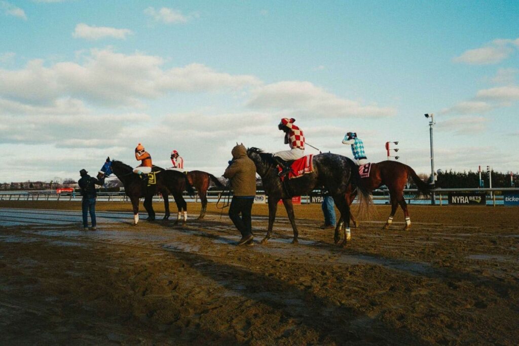 Horses and riders on the Aqueduct Racetrack surface during NYRA's farewell weekend coverage. Credit: Henry Kornaros / NYRA.